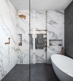 a white bath tub sitting next to a walk in shower