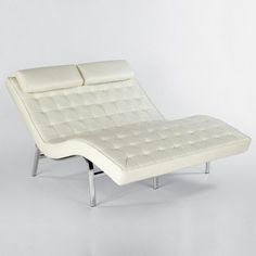 a white leather chaise lounge chair with chrome legs