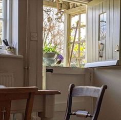 a chair sitting in front of a window next to a wooden table