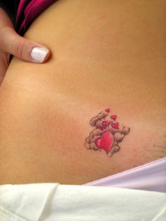 a pregnant woman's stomach with a tattoo on it that has hearts in the shape of a teddy bear