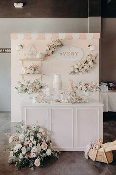 a table with flowers on it next to a sign that says avery and some baskets