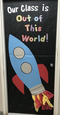 a door decorated with a rocket ship and the words our class is out of this world