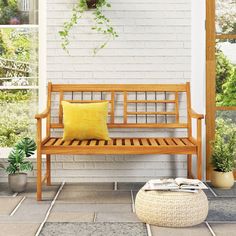 a wooden bench sitting on top of a tiled floor next to a white brick wall