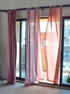 pink curtains are hanging in front of a sliding glass door