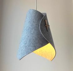 a gray and yellow light hanging from a ceiling fixture with a cross on the side