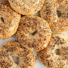 bagels with sesame seeds and poppy seed sprinkles on white parchment paper