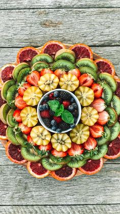 a platter filled with sliced fruit on top of a wooden table