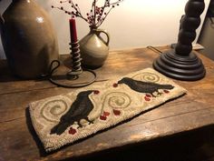 a table with two vases and a rug on it next to a candle holder