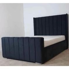 a bed that is in the middle of a room with white walls and flooring