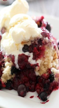 a piece of cake on a plate with ice cream and blueberry toppings in it