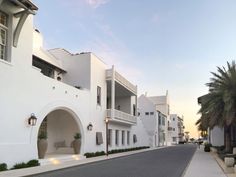 a street lined with white buildings and palm trees