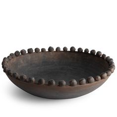 a brown bowl with beads on the rim