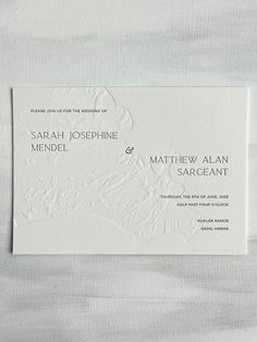 a white and black wedding card on top of a piece of paper with the words,