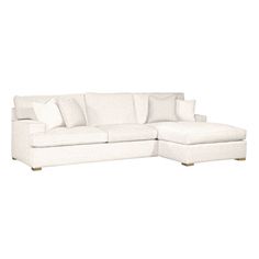 a white sectional couch with pillows on it's back and the seat folded down