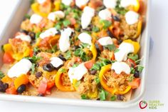 a tray filled with stuffed bell peppers topped with cheese and black olives on top