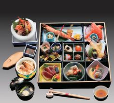 an assortment of sushi and chopsticks on a tray