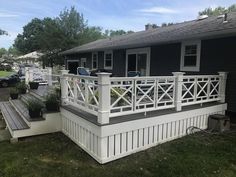 a house with white railings and black siding