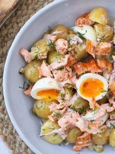 a white bowl filled with potato salad and hard boiled eggs