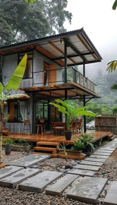 the house is surrounded by greenery and stone steps leading up to it's deck