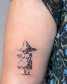 a woman's arm with a small black and white drawing of a wizard on it