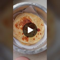 two flat breads sitting on top of a metal pan next to a person's hand