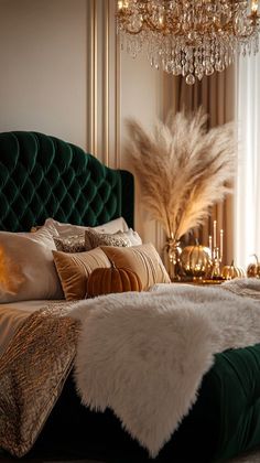 a green velvet bed with gold and white pillows, chandelier in the background