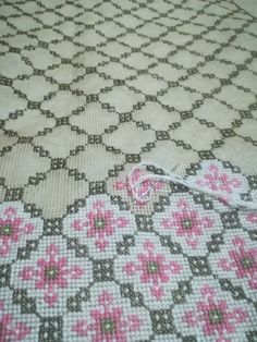 a piece of cloth with pink flowers on it and a white string in the middle