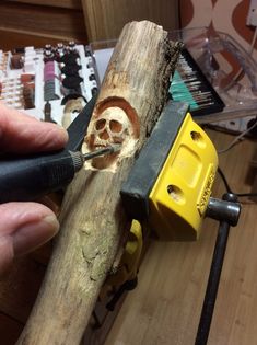 a person is carving a skull on a piece of wood