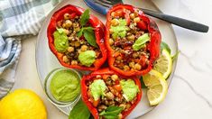 three stuffed peppers with guacamole and garnishes on a plate