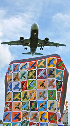 an airplane is flying over a large quilt