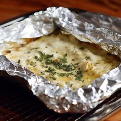 some food that is sitting in tin foil on a grilling pan and ready to be eaten