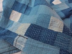 a close up of a blue quilt on a bed