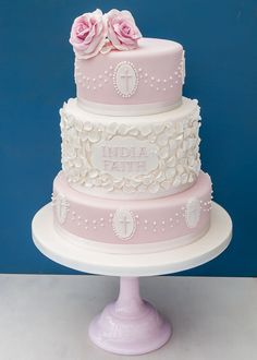 a three tiered cake with pink flowers on top