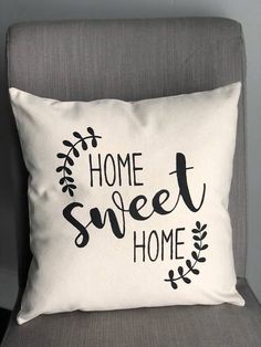 a pillow that says home sweet home on the back of a chair with a plant