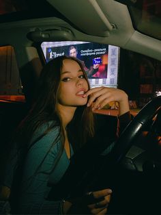 a woman sitting in the driver's seat of a car