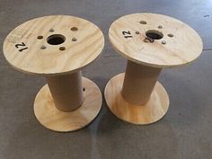 two wooden spools sitting on top of each other in the middle of a floor