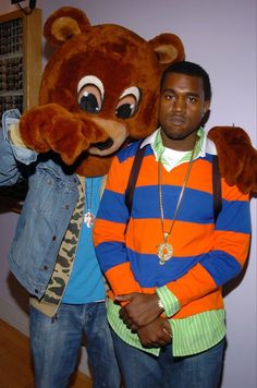 two men standing next to each other in front of a stuffed animal