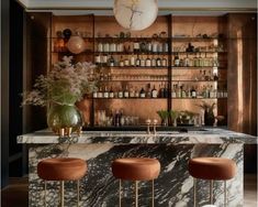 an elegant bar with marble counter tops and stools