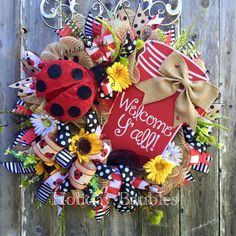 a wreath with a ladybug, sunflowers and a welcome sign on it