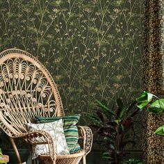 a wicker chair sitting in front of a green wall