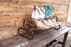 three pairs of cowboy boots are sitting on a bench