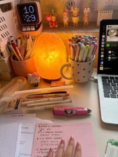 an open laptop computer sitting on top of a desk next to a notebook and pen