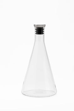 a glass flask with a black top on a white background in the shape of a cone