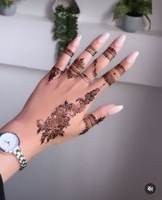 a woman's hand with henna tattoos on it