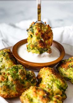 broccoli and cheese muffins on a plate with a fork in it