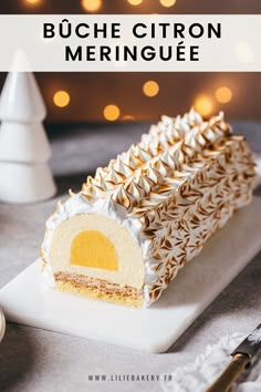 a close up of a slice of cake on a plate with christmas lights in the background