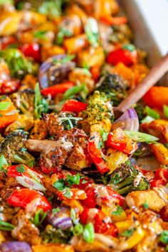 a casserole dish with broccoli, red peppers and other vegetables