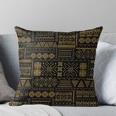 a black and gold throw pillow sitting on top of a couch