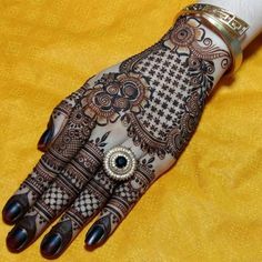 the hand is decorated with henna and jewels