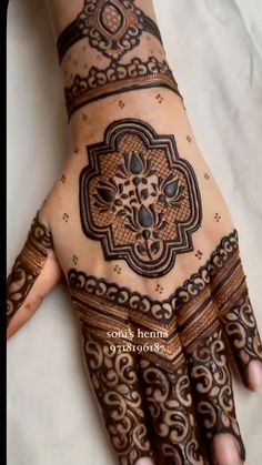 a woman's hand with henna tattoos on it